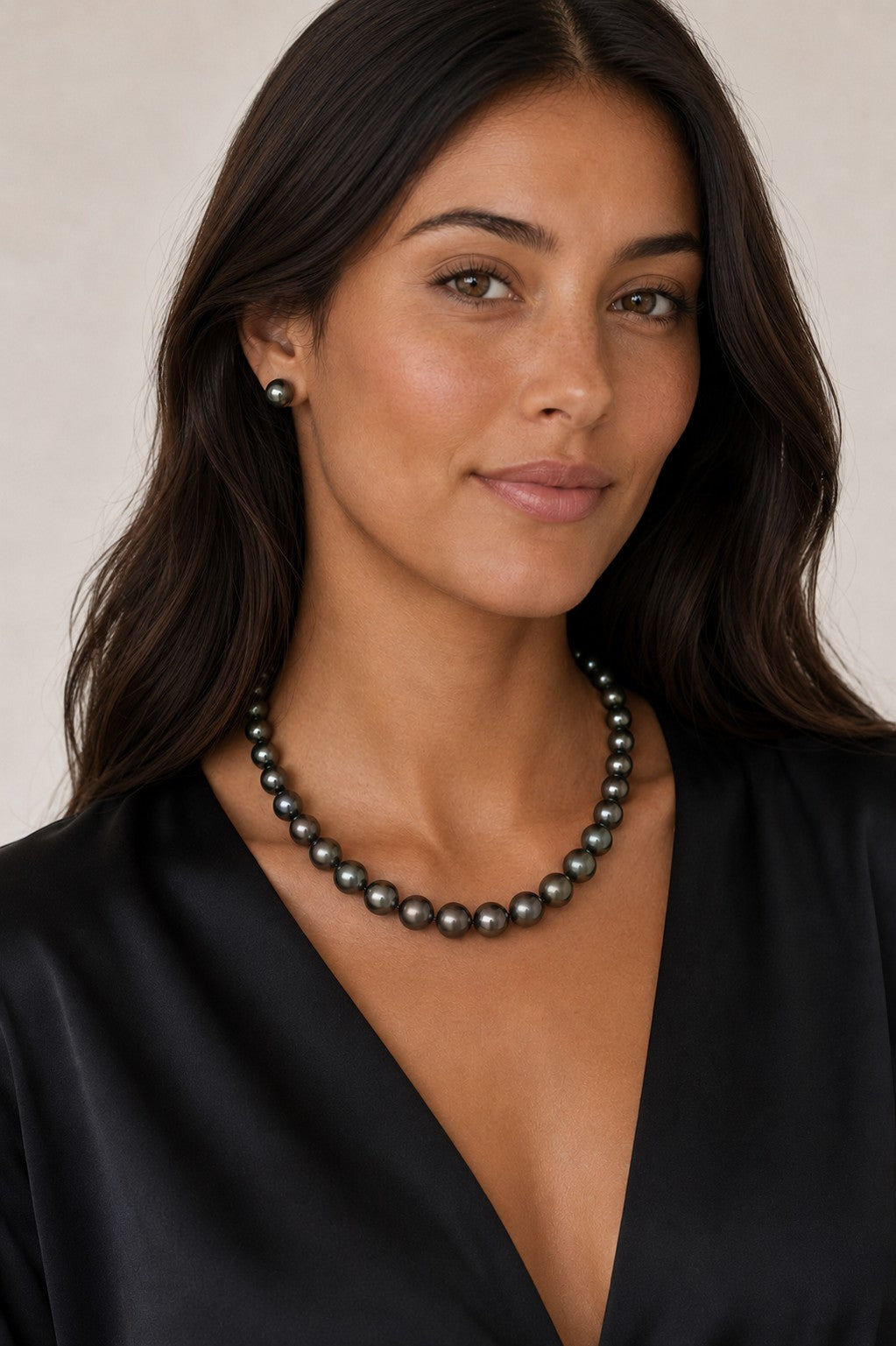 Model wearing a Prestige Pearl hand-knotted 9-11mm round black Tahitian pearl necklace with matching stud earrings.