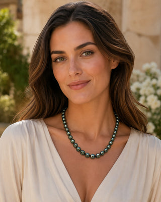 Prestige Pearl dark Tahitian circle baroque pearl necklace worn by a woman in a cream blouse