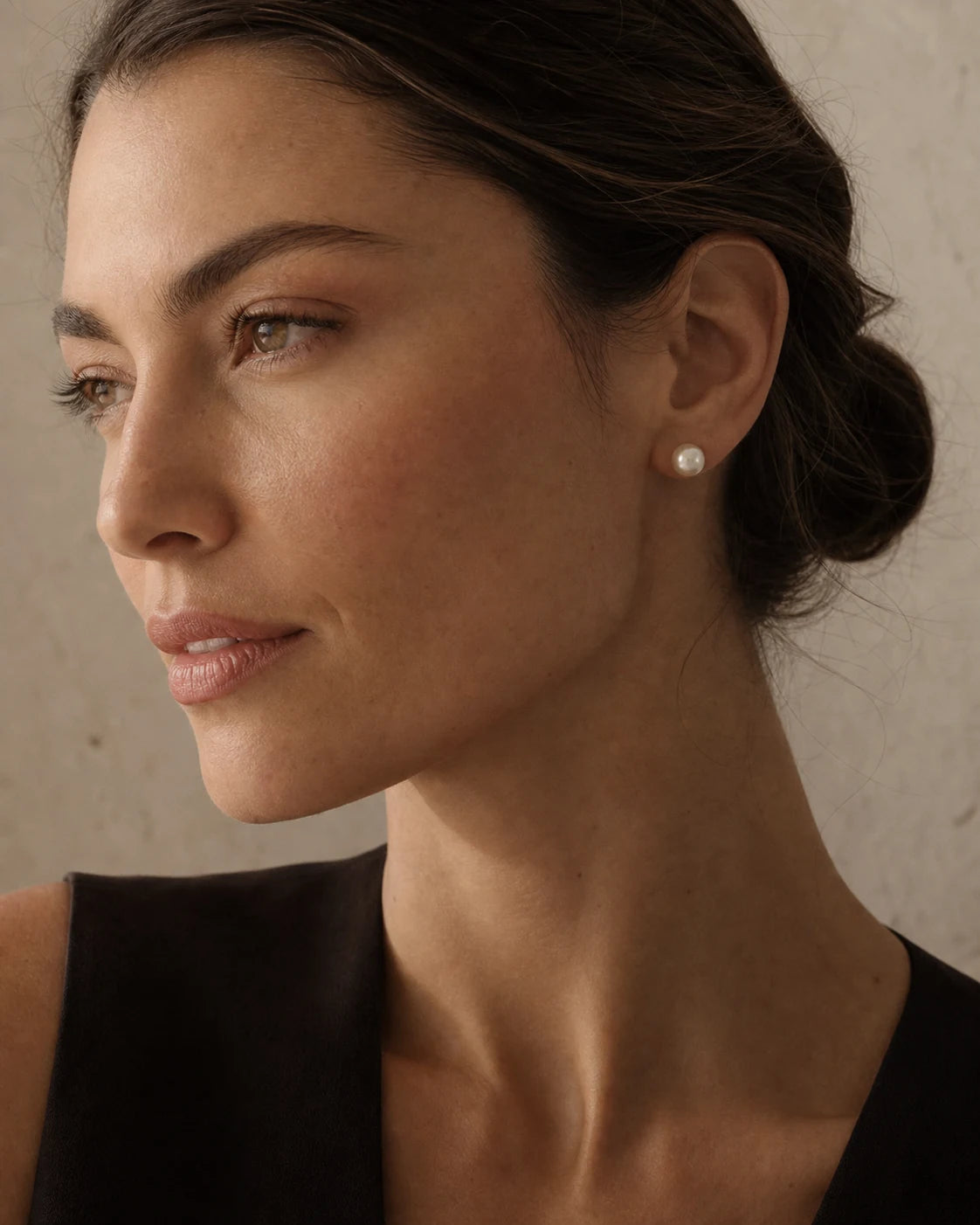 Woman in profile wearing a white pearl stud earring