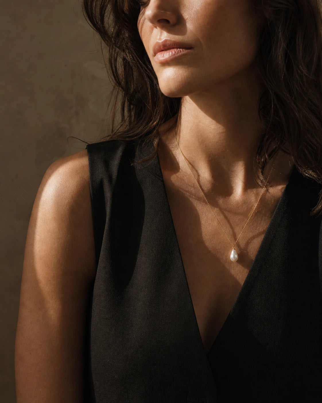 Woman wearing a teardrop white pearl pendant