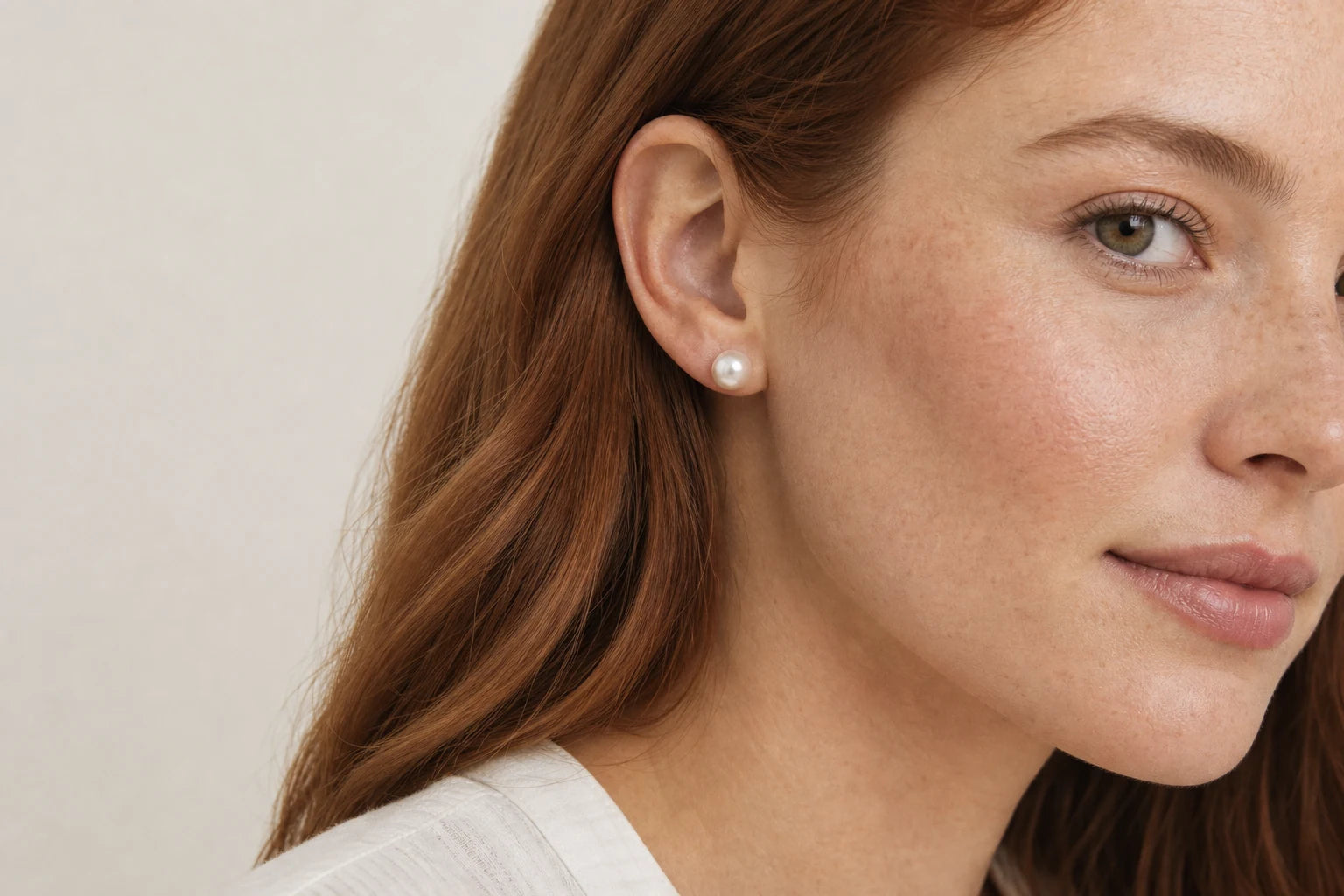 Model wearing a white pearl stud earring